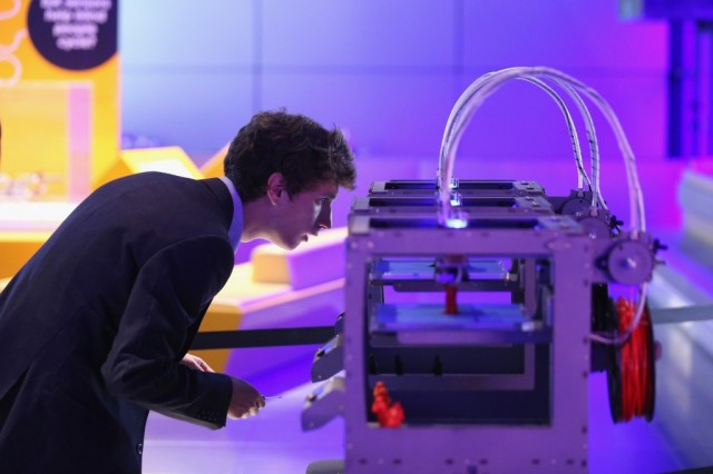 A technician checks on a 3D printer as it constructs a model human figure in the exhibition '3D: printing the future' in the Science Museum on October 8, 2013 in London, England. The exhibition, which opens to the public tomorrow, features over 600 3D printed objects ranging from: replacement organs, artworks, aircraft parts and a handgun. (Photo by Oli Scarff/Getty Images)