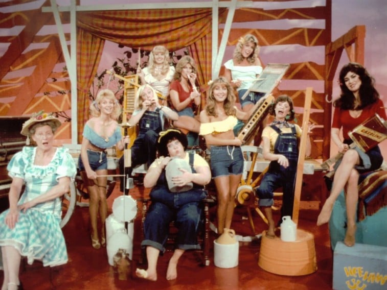 Un groupe de femmes joue des instruments en salopette dans Hee Haw Honeys