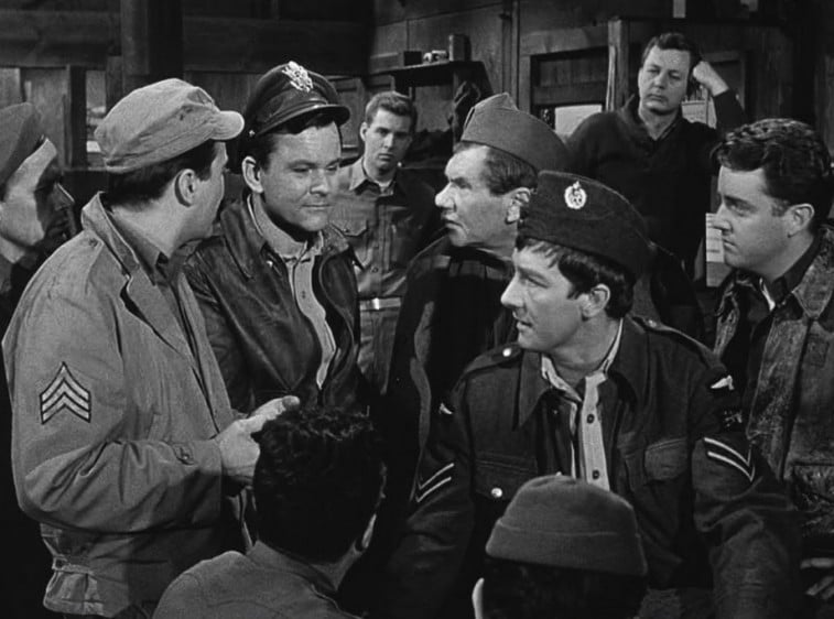 Een groep soldaten uit de Tweede Wereldoorlog praat in een scène uit Hogan's Heroes