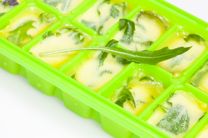 Ice cube tray with herbs and oil