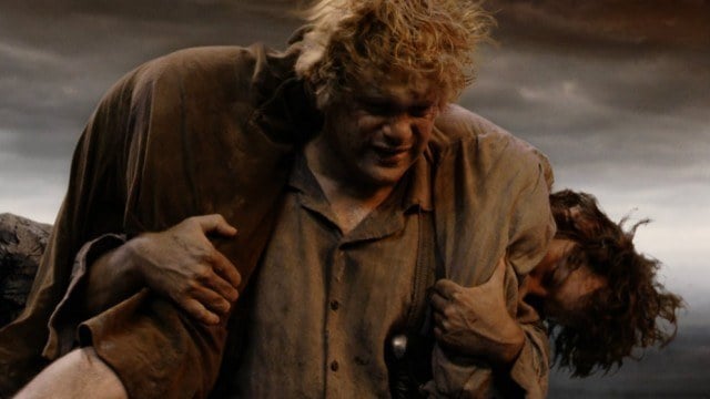 Sam carries a wounded Frodo on his shoulders. 