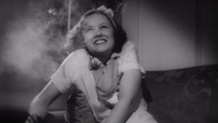 Woman smiling in a room filled with smoke in Reefer Madness