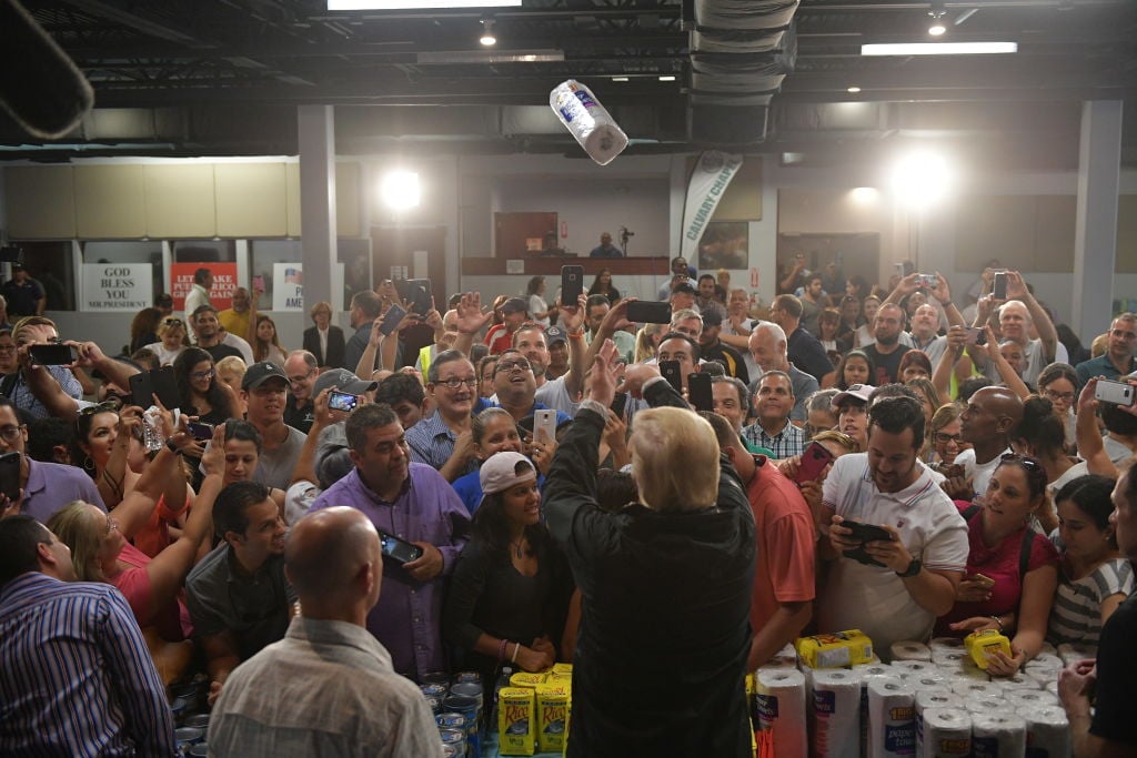 Donald Trump tossing a roll of paper towels into a crowd of people