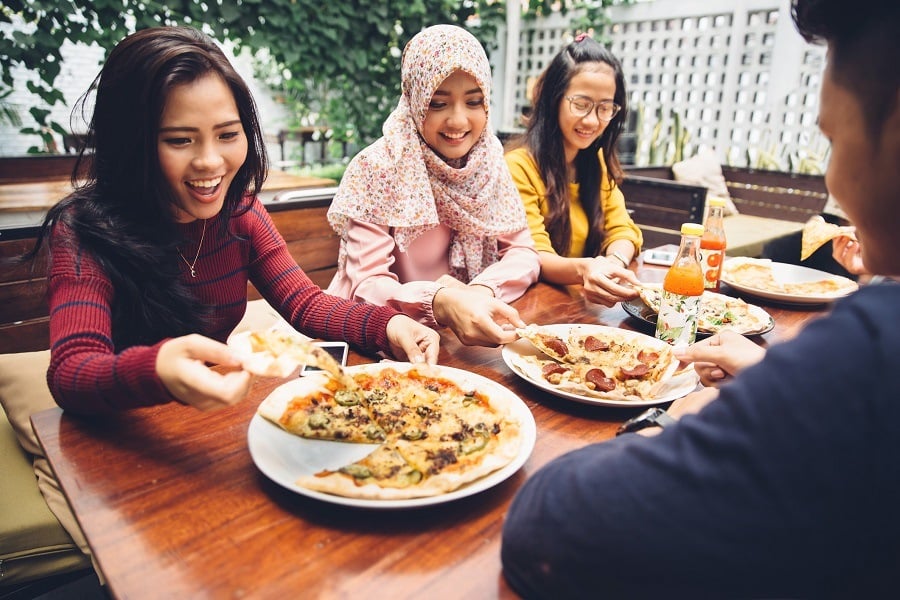 Group Of Young Friends Enjoying Meal In Outdoor Restaurant