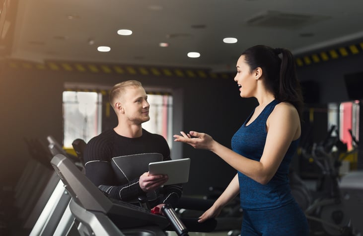 Personal trainer helping a girl at the gym