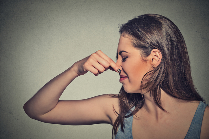 A woman holds her nose to avoid bad smells