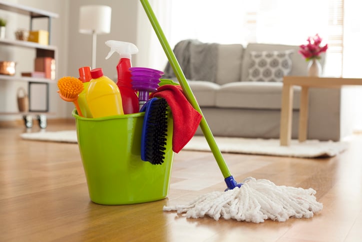 Bucket of cleaning products next to a mop.