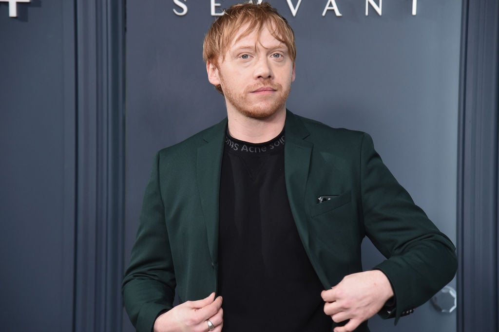 Rupert Grint smiling in a green jacket