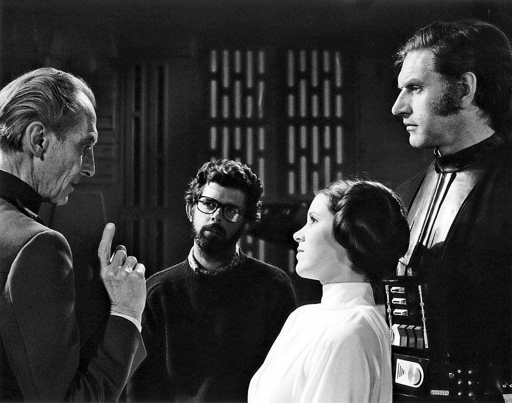 Peter Cushing, David Prowse, and Carrie Fisher with director, screenwriter, and producer George Lucas on the set of his movie 'Star Wars: Episode IV - A New Hope.'