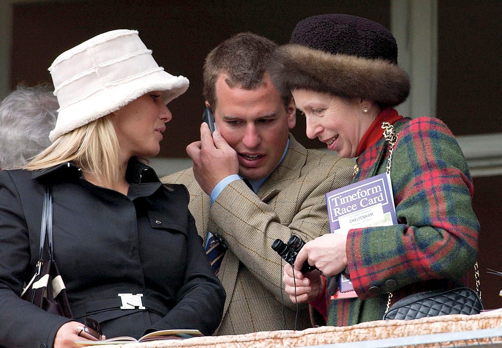 As Peter Phillips Chats On His Mobile Phone Princess Anne And Zara Phillips Move In Close To Listen At The National Hunt Festival At Cheltenham Races