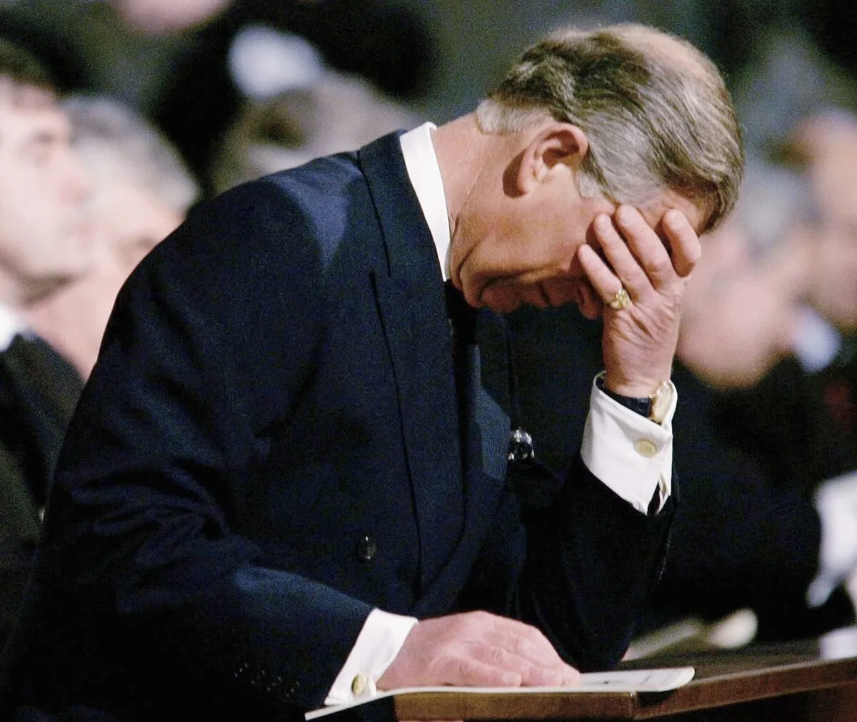 Then-Prince Charles with his head in his hand as he's overcome with grief