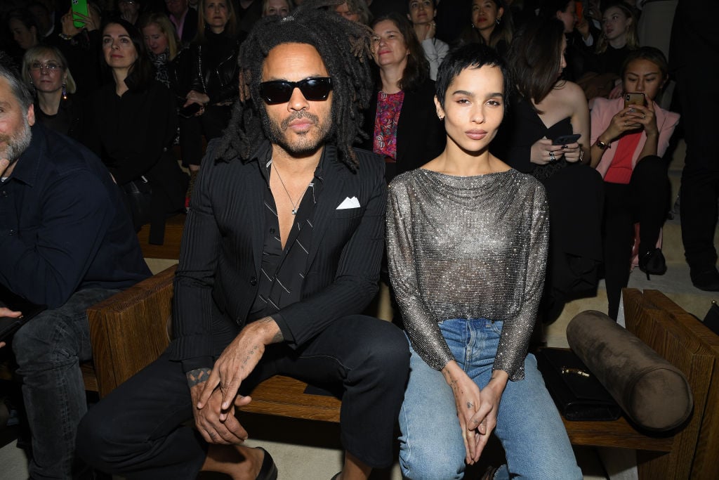 (L-R) Lenny Kravitz and Zoe Kravitz looking at a camera, sitting in front of a group of people