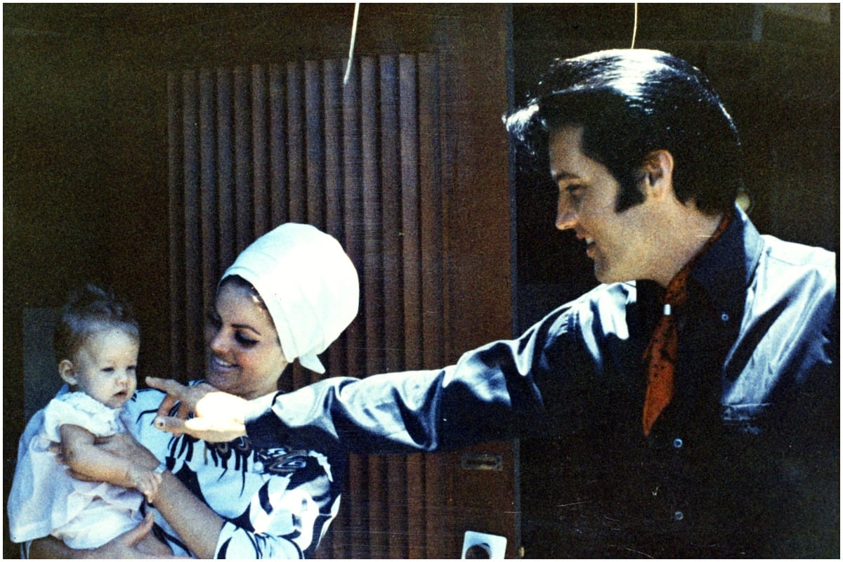 Elvis Presley posing with daughter Lisa Marie Presley and ex-wife Priscilla Presley