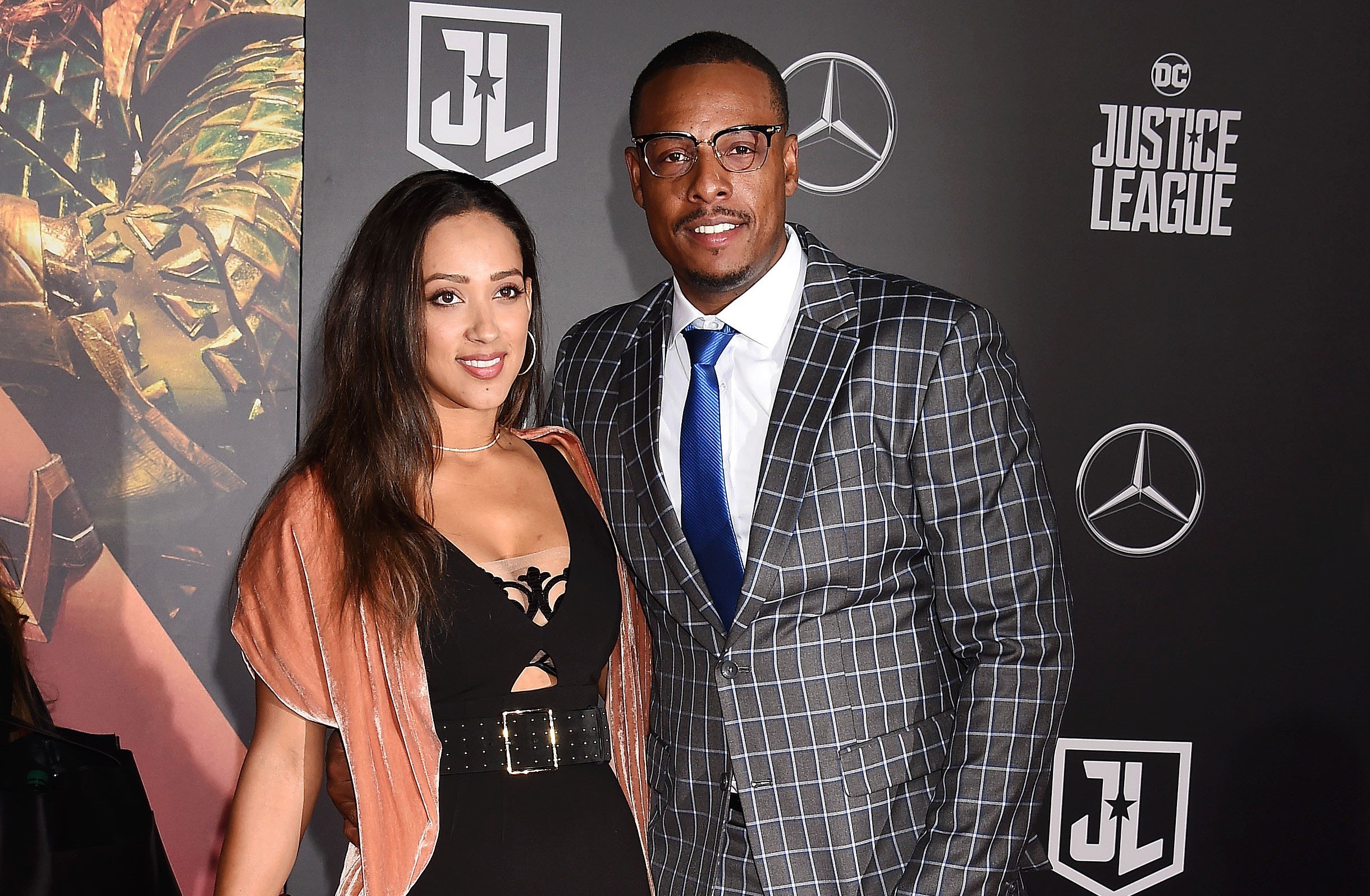 Former NBA player Paul Pierce in patterned suit and his wife, Julie Landrum, in a black dress posing on red carpet at movie premiere