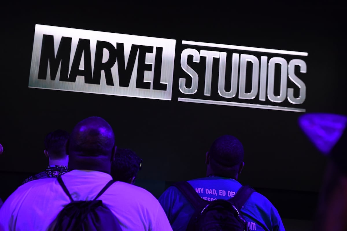 Attendees watch Marvel Studios visual at the Disney+ booth at the D23 Expo