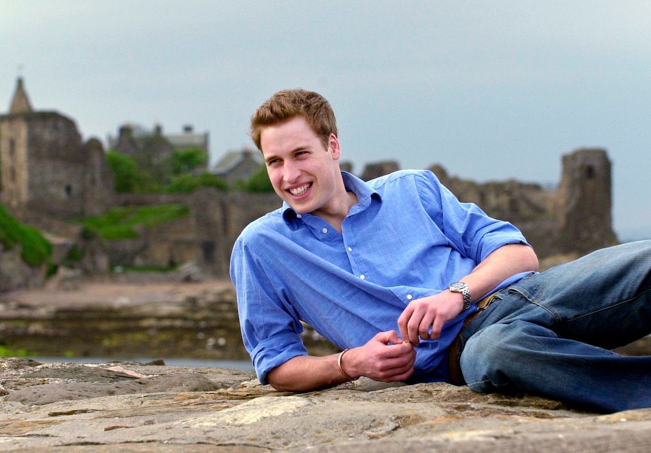 Prince William relaxing on rocky surface at a pier
