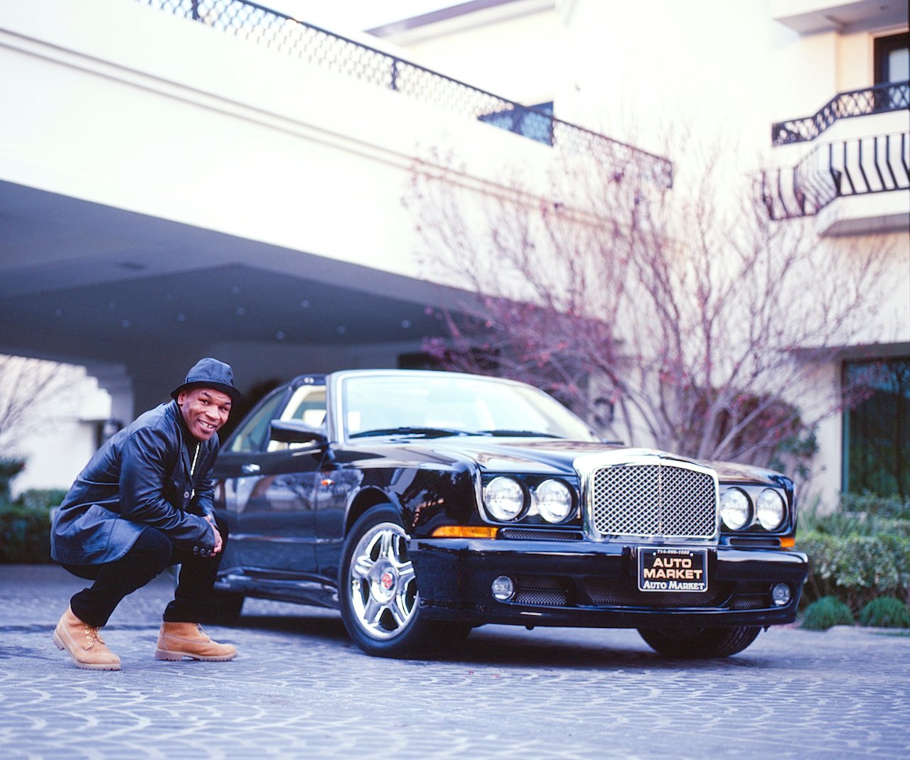 Mike Tyson poses at his home in 2000 with his Jaguar and Bentley 