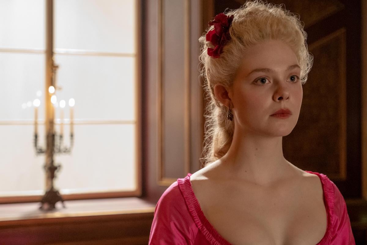 Elle Fanning as Catherine, wearing a pink dress and in front of a window, in 'The Great'