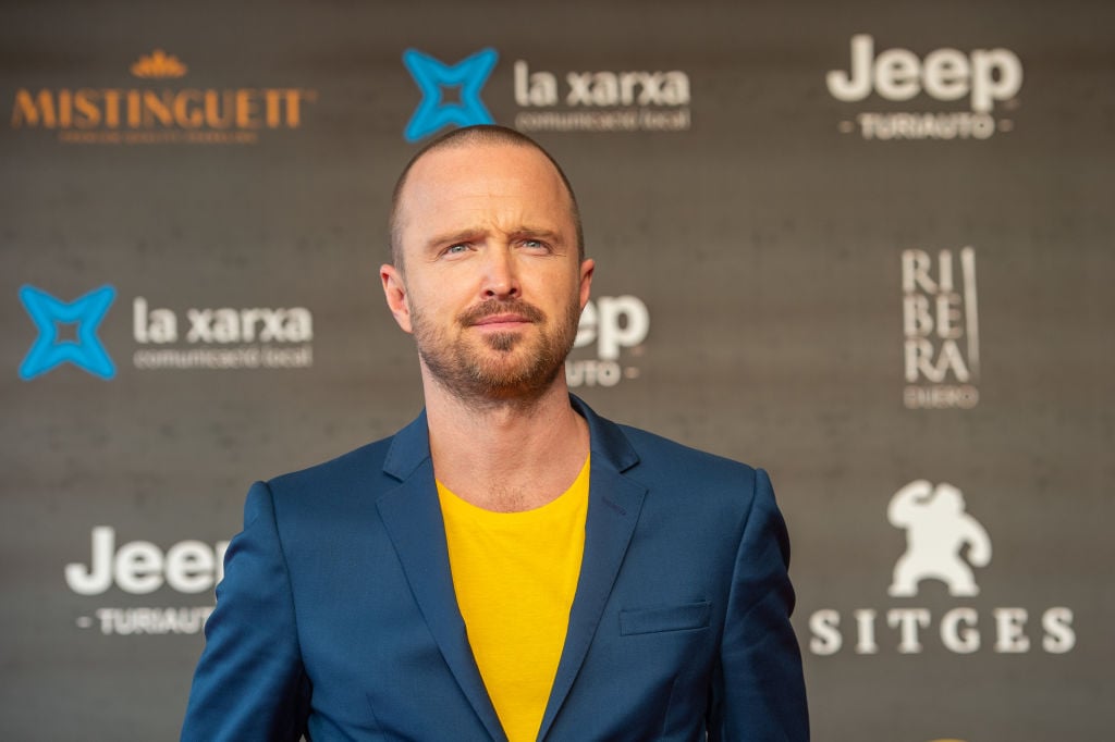 Aaron Paul attends 'El Camino: A Breaking Bad Movie' in a blue suit jacket and yellow undershirt.