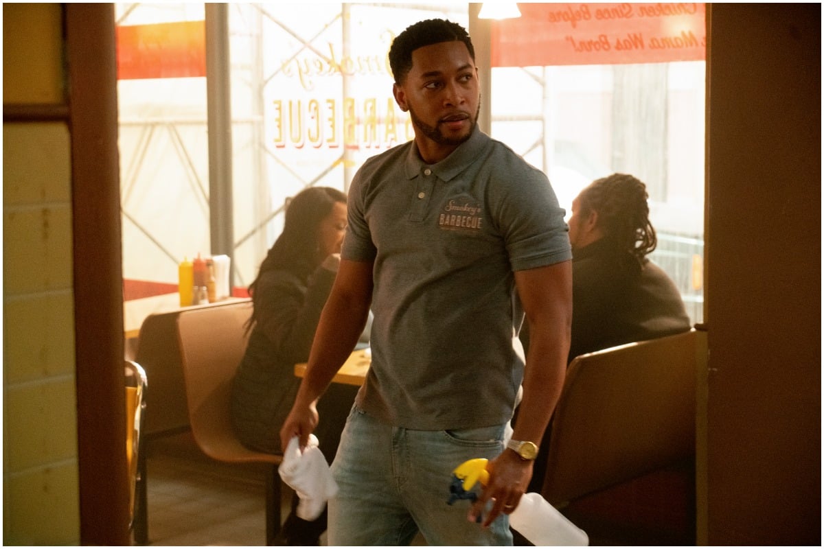 'The Chi' actor Jacob Latimore as Emmett holding a spray bottle while scowling.