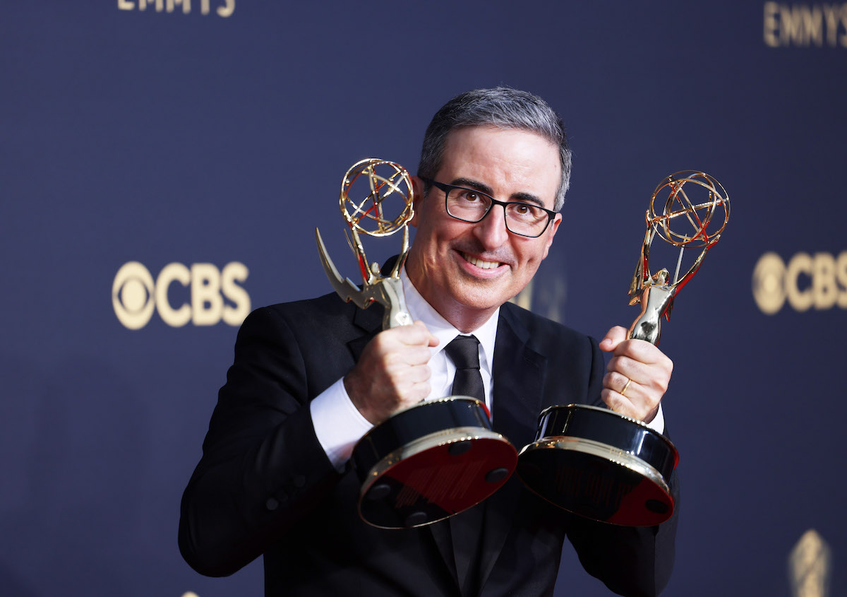 John Oliver at the 2021 Emmy Awards holding two Emmys.