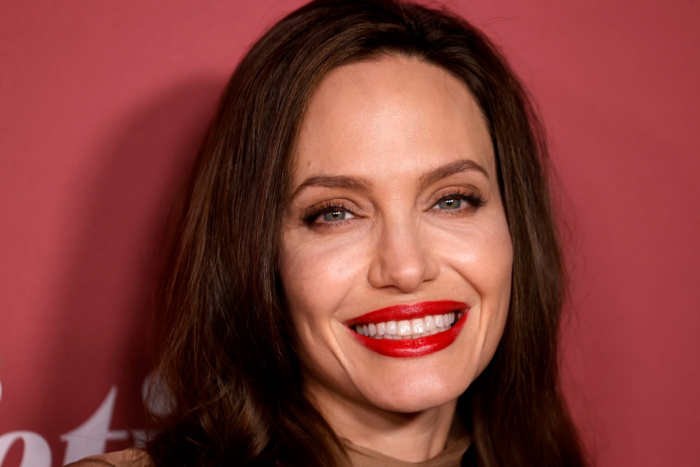 Angelina Jolie in front of a red background.