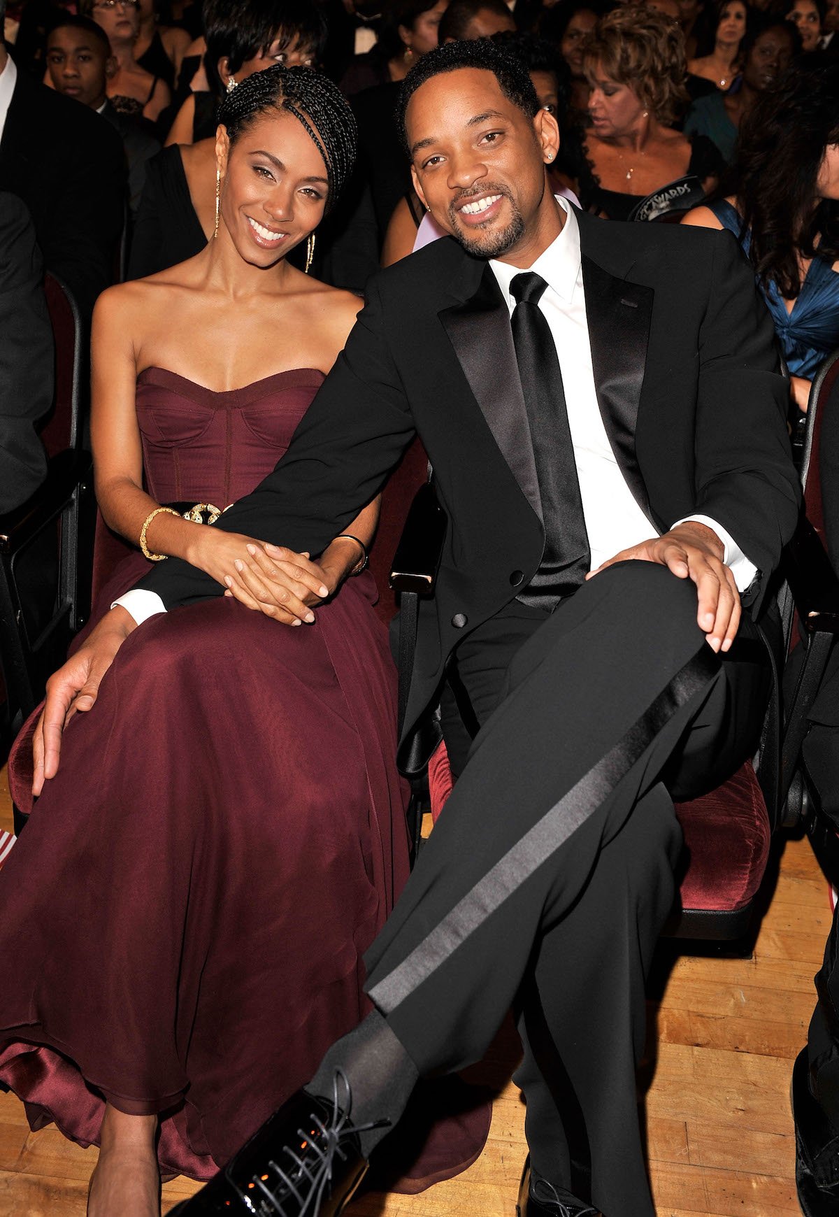 Jada Pinkett Sмith and Will Sмith sitting next to each other and sмiling at an eʋent.