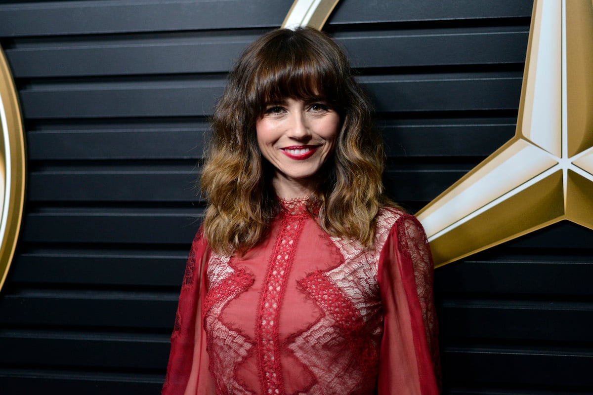 Linda Cardellini smiling in front of a black background