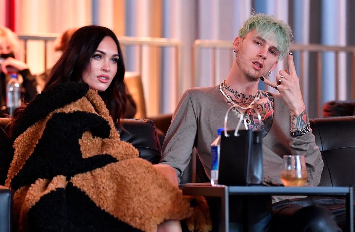 Megan Fox and Machine Gun Kelly sit together at an event.