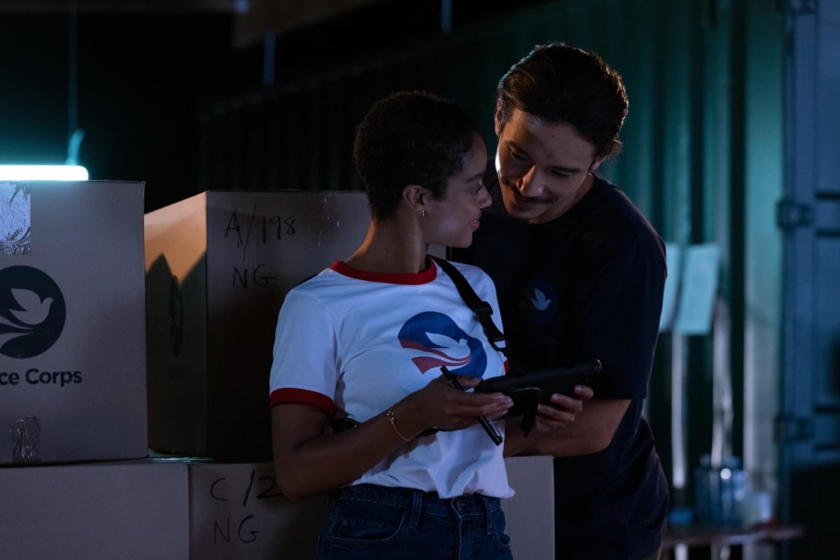 Yao and Delilah smile and at each other while working in the Peace Corps in the 'Nine Perfect Strangers' finale. Delilah and Yao are both wearing Peace Corps t-shirts. 