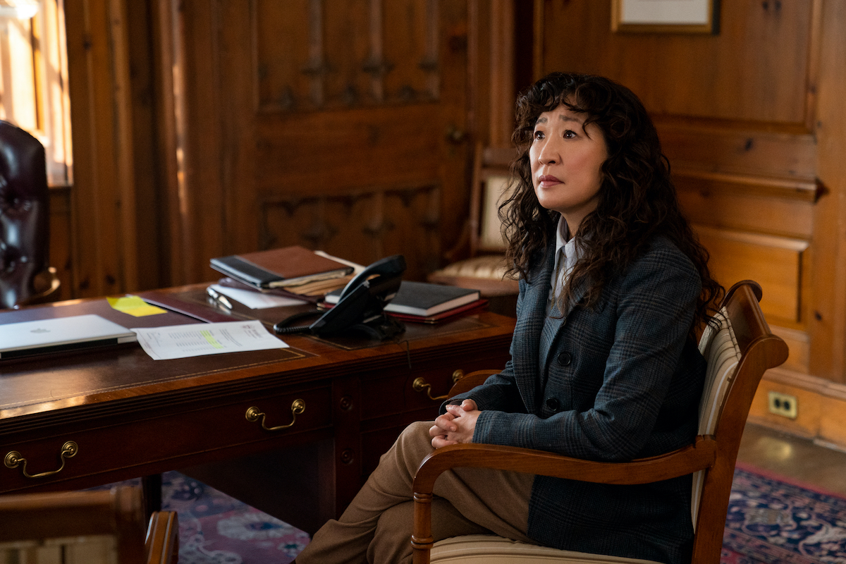 Sandra Oh as Ji-Yoon, sitting in a wood-paneled room