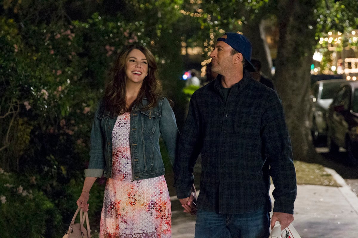 Lauren Graham as Lorelai Gilmore and Scott Patterson as Luke Danes smiling, holding hands in 'Gilmore Girls: A Year in the Life'