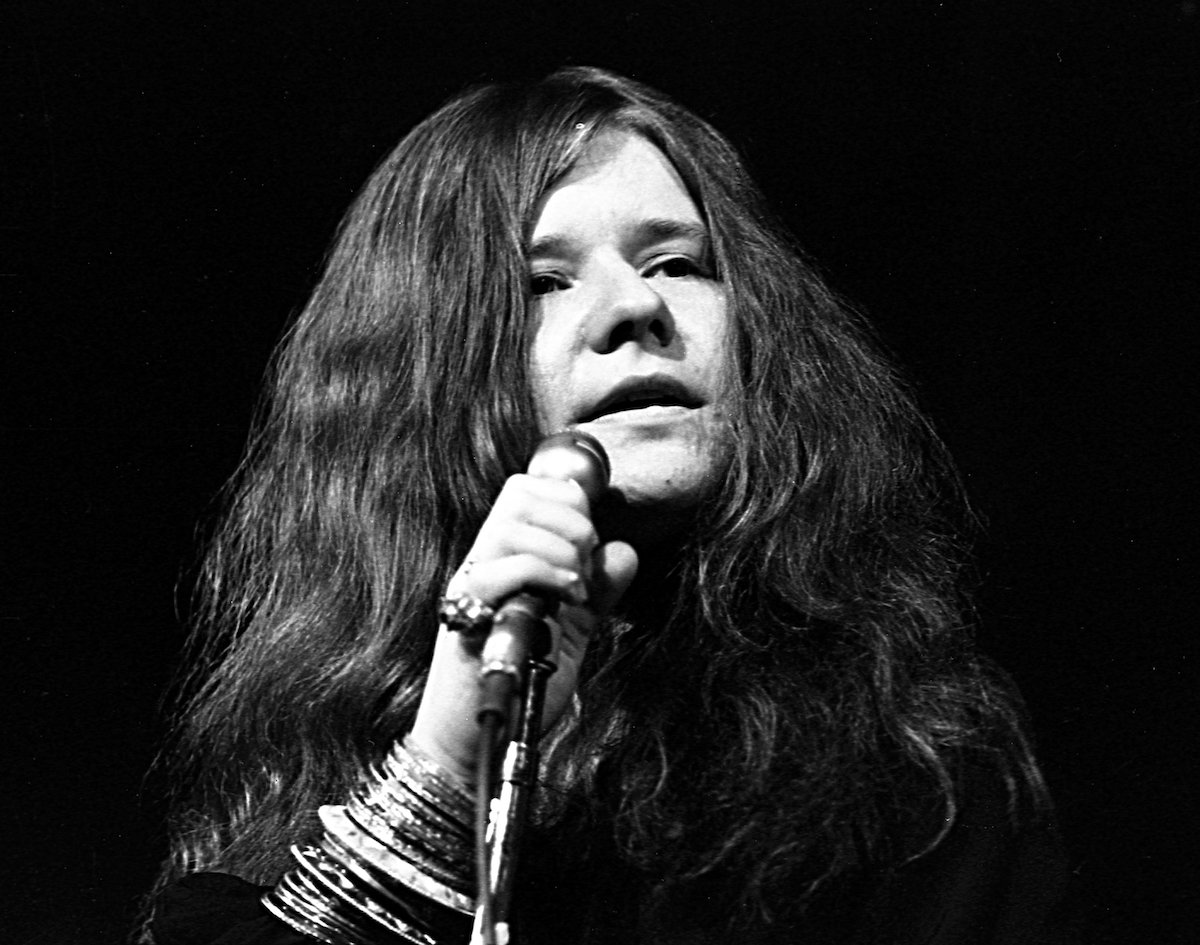 Janis Joplin sings into a microphone.