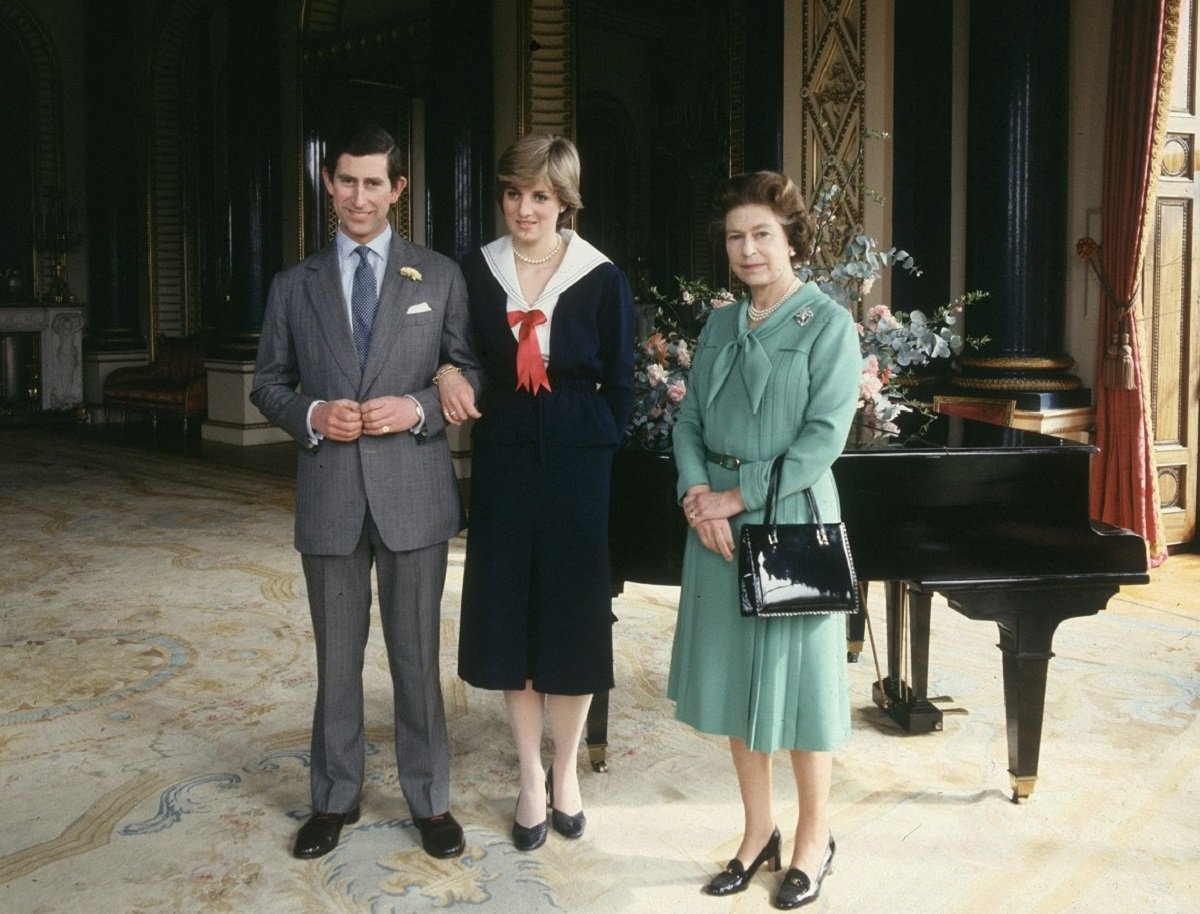 Photo of Queen Elizabeth II with Prince Charles and Lady Diana Spencer (later Princess Diana) inside Buckingham Palace