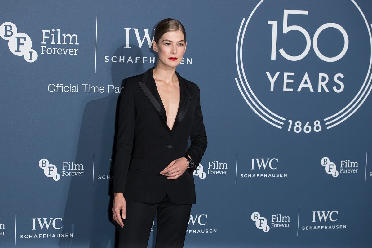 Rosamund Pike posing in a black dress