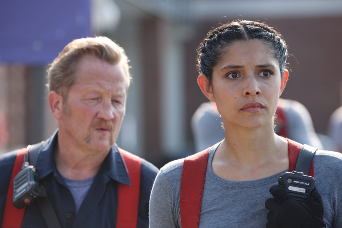 Christian Stolte as Randall “Mouch” McHolland and Miranda Rae Mayo as Stella Kidd in Chicago Fire Season 10. Stella stands next to Mouch with a serious look on her face.