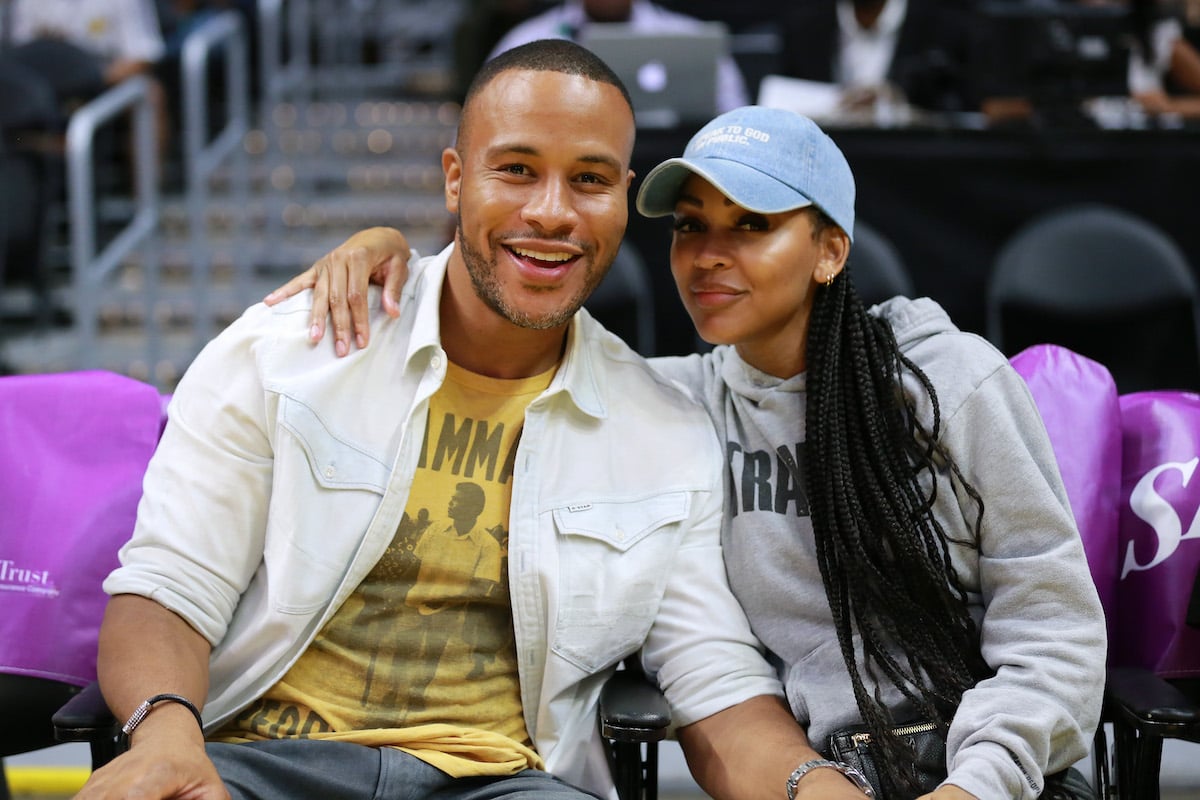 DeVon Franklin and Meagan Good pose at sporting event