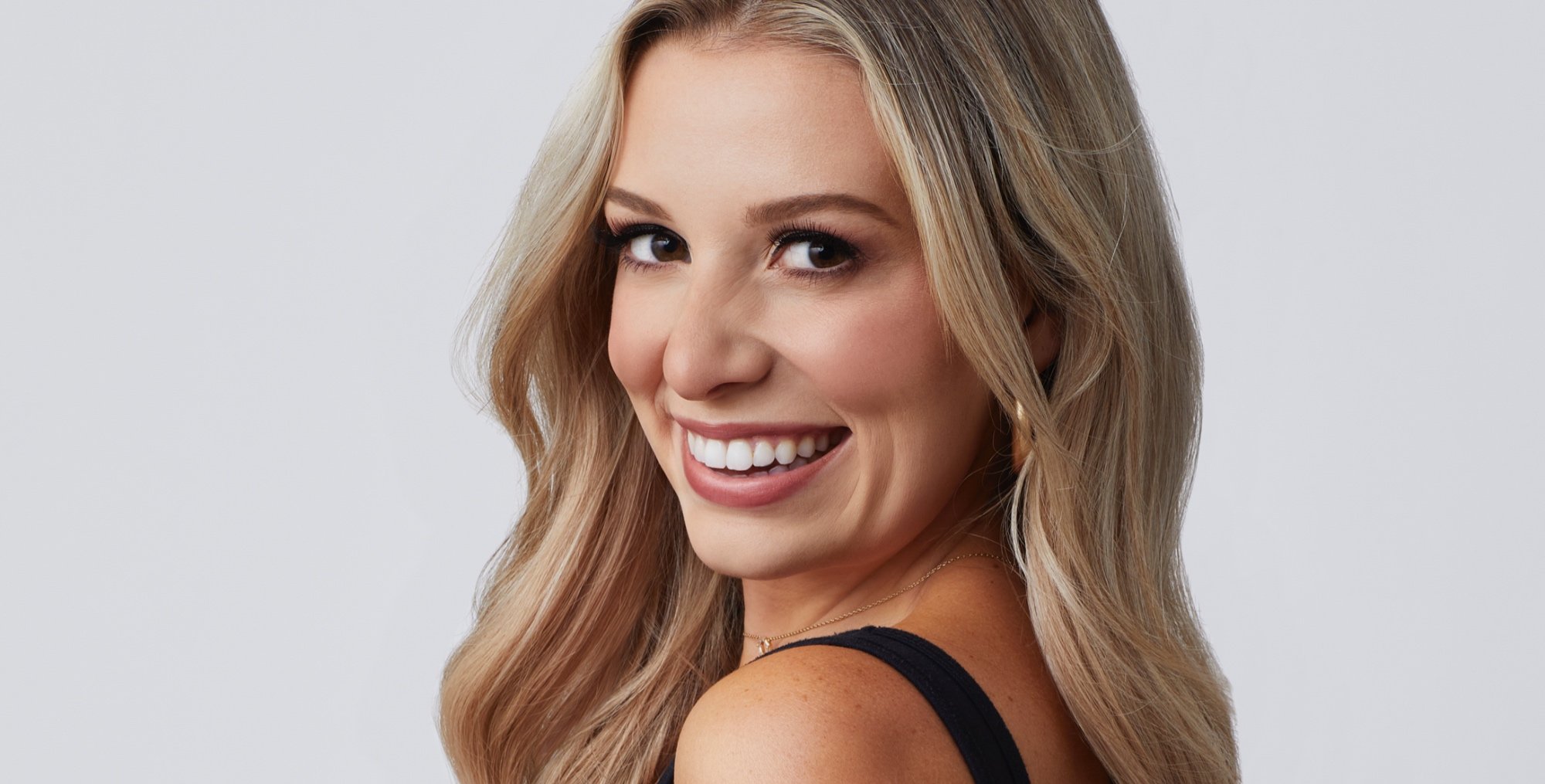 Hunter Haag for 'The Bachelor' 2022 Season 26 wearing black top and smiling.