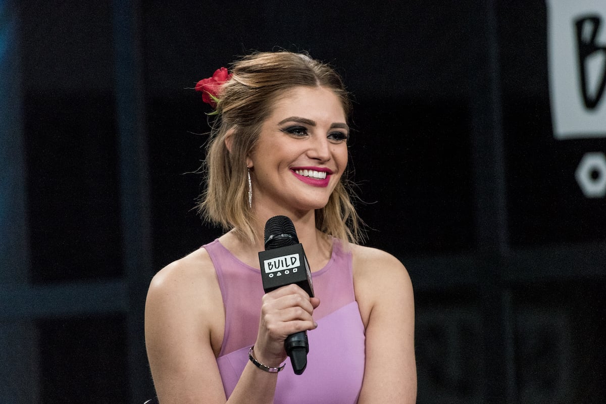 Olivia Caridi smiling, holding a microphone