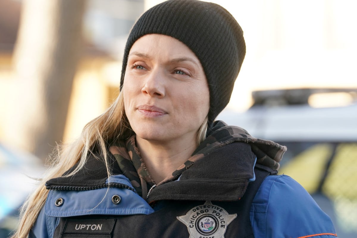Tracy Spiridakos as Hailey in Chicago P.D. Season 9. Upton wears a black hat and bullet-proof vest.