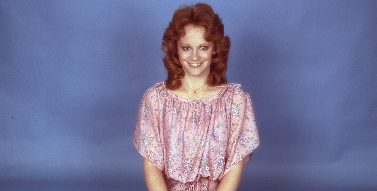 Reba McEntire poses for a portrait in a pink dress circa 1976.
