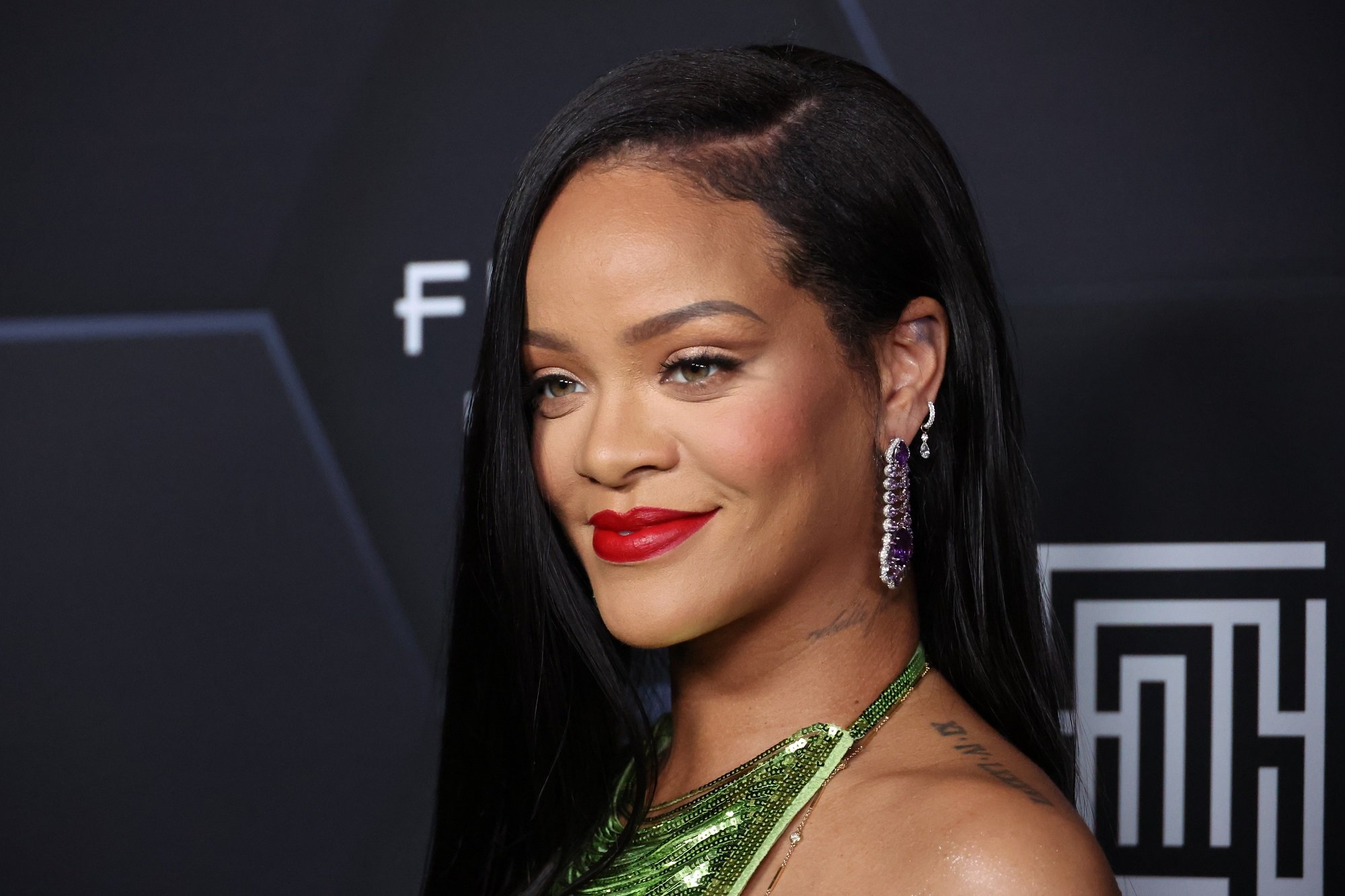 Rihanna sourit devant un fond noir