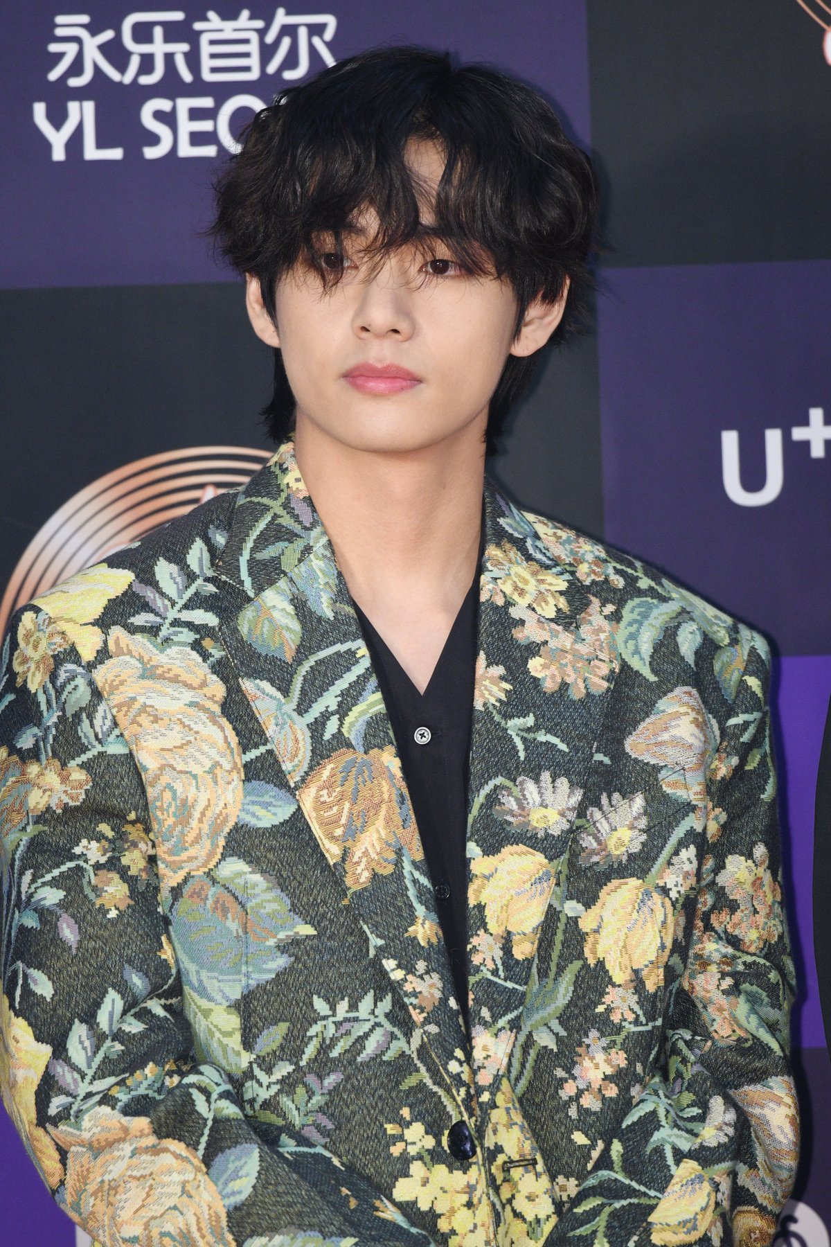 BTS member, V, looks serious as he poses on the red carpet at the Golden Disc Awards in Seoul, South Korea.