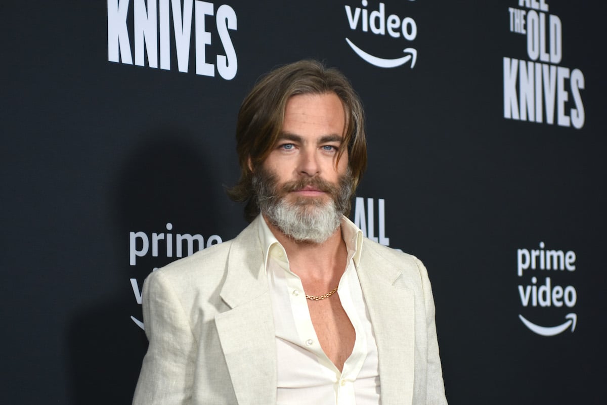 Chris Pine smiling in front of a black background