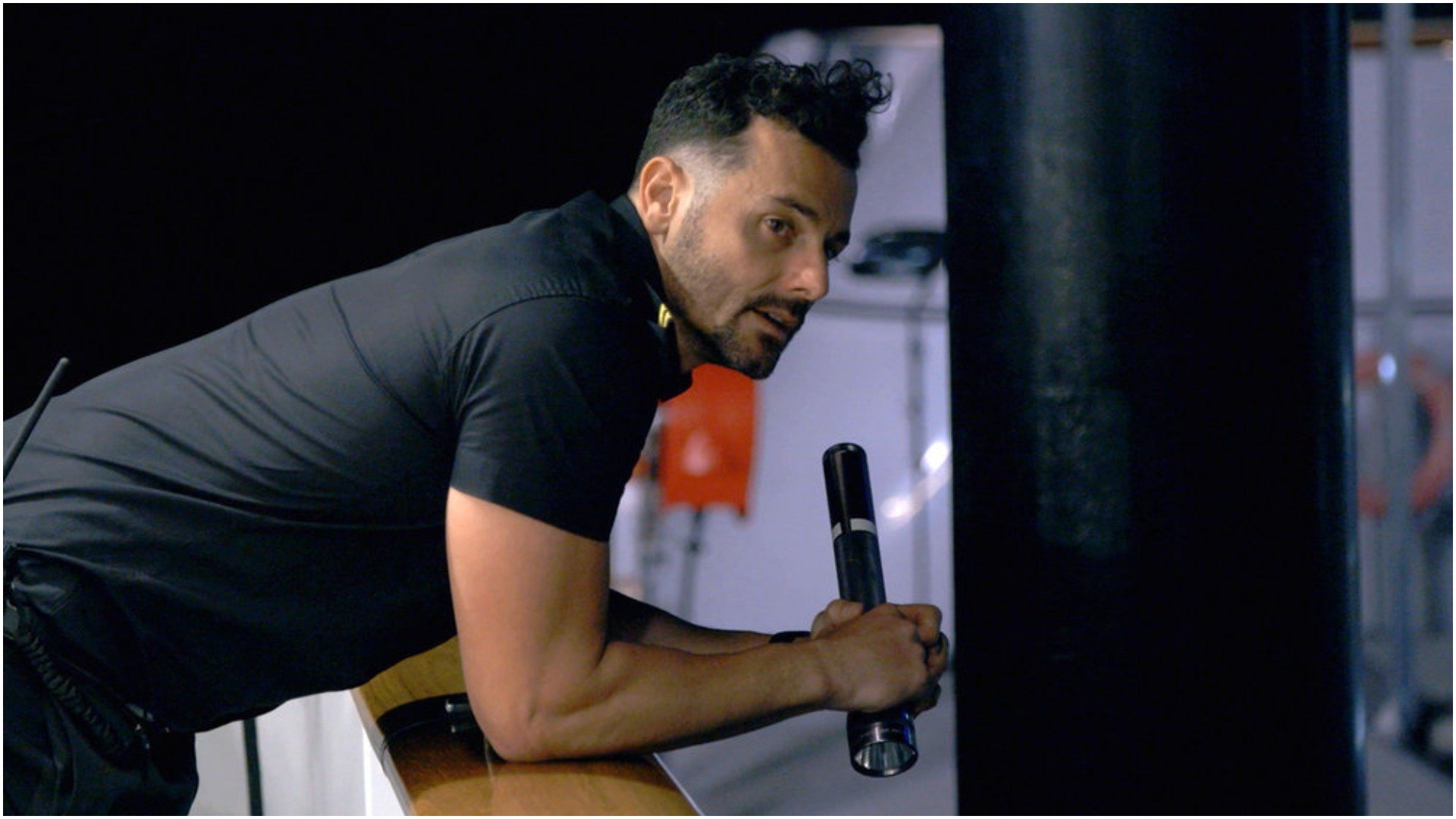 Jamie Sayed from 'Below Deck Down Under' leans over the side of the boat holding a flashlight 