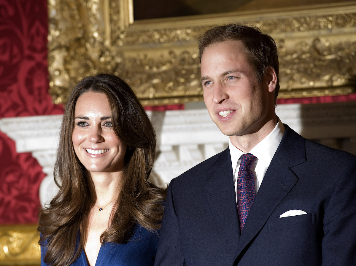 Kate Middleton and Prince William smile as they stand next to each other