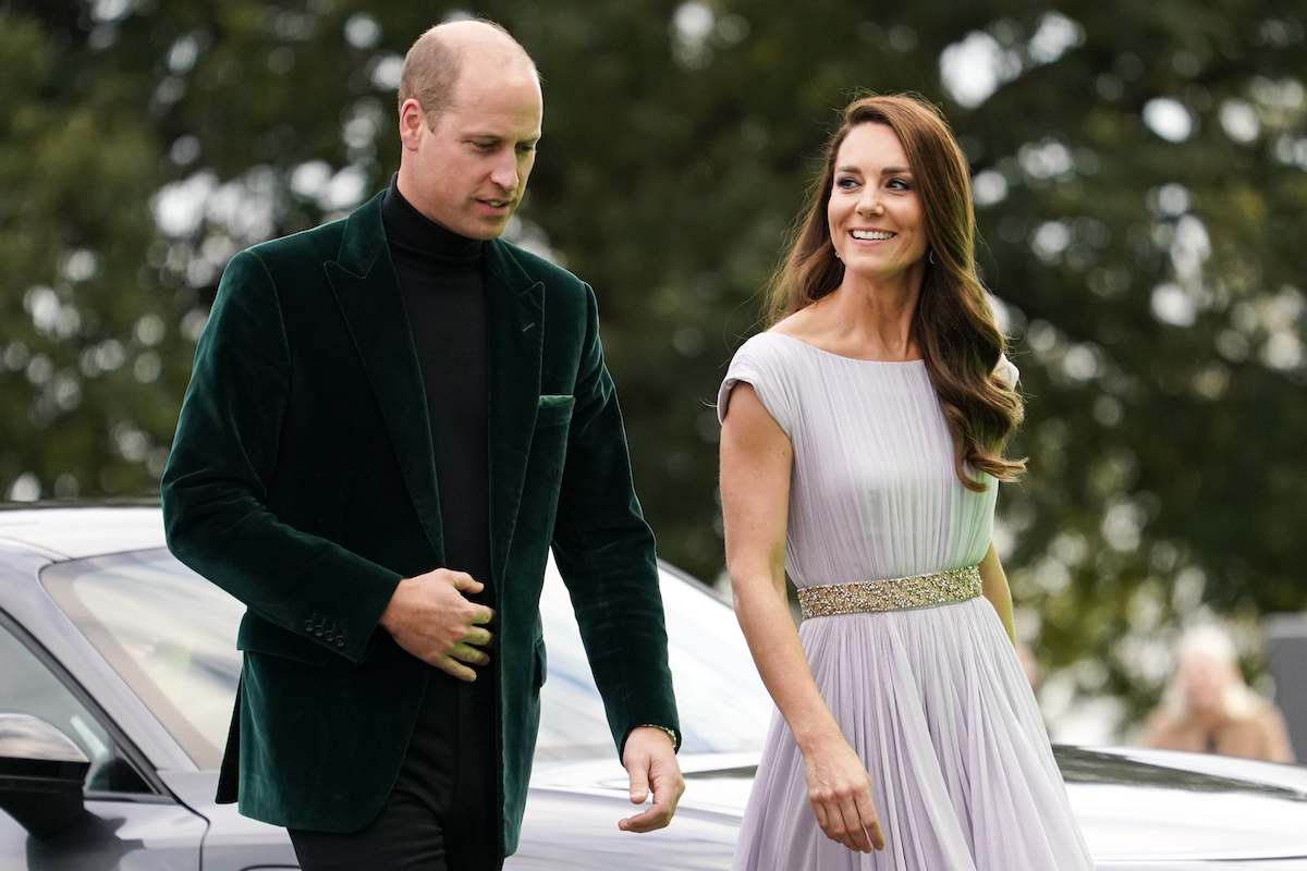 Prince William wears a green jacket as he walks next to Kate Middleton in a blue gown