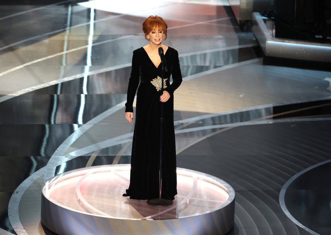 Reba McEntire performs onstage in a black gown at the 94th Academy 