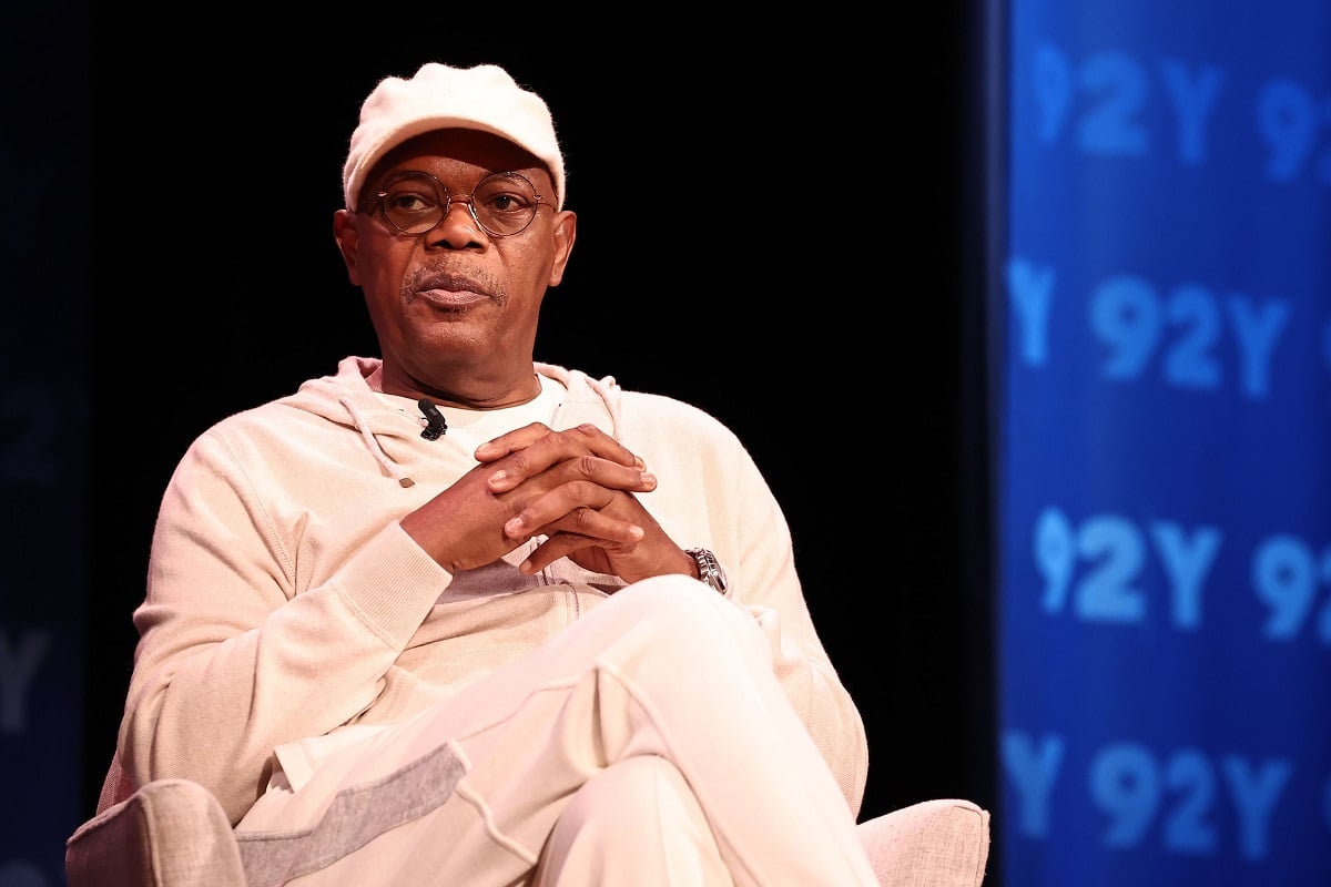 Samuel L. Jackson sitting down while wearing white clothes.