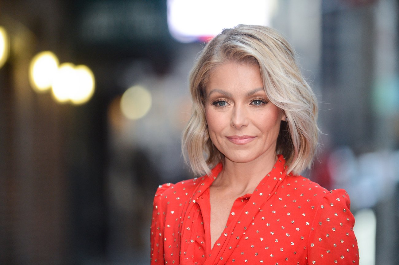 Kelly Ripa wearing a red outfit and looking toward the left side of the photo